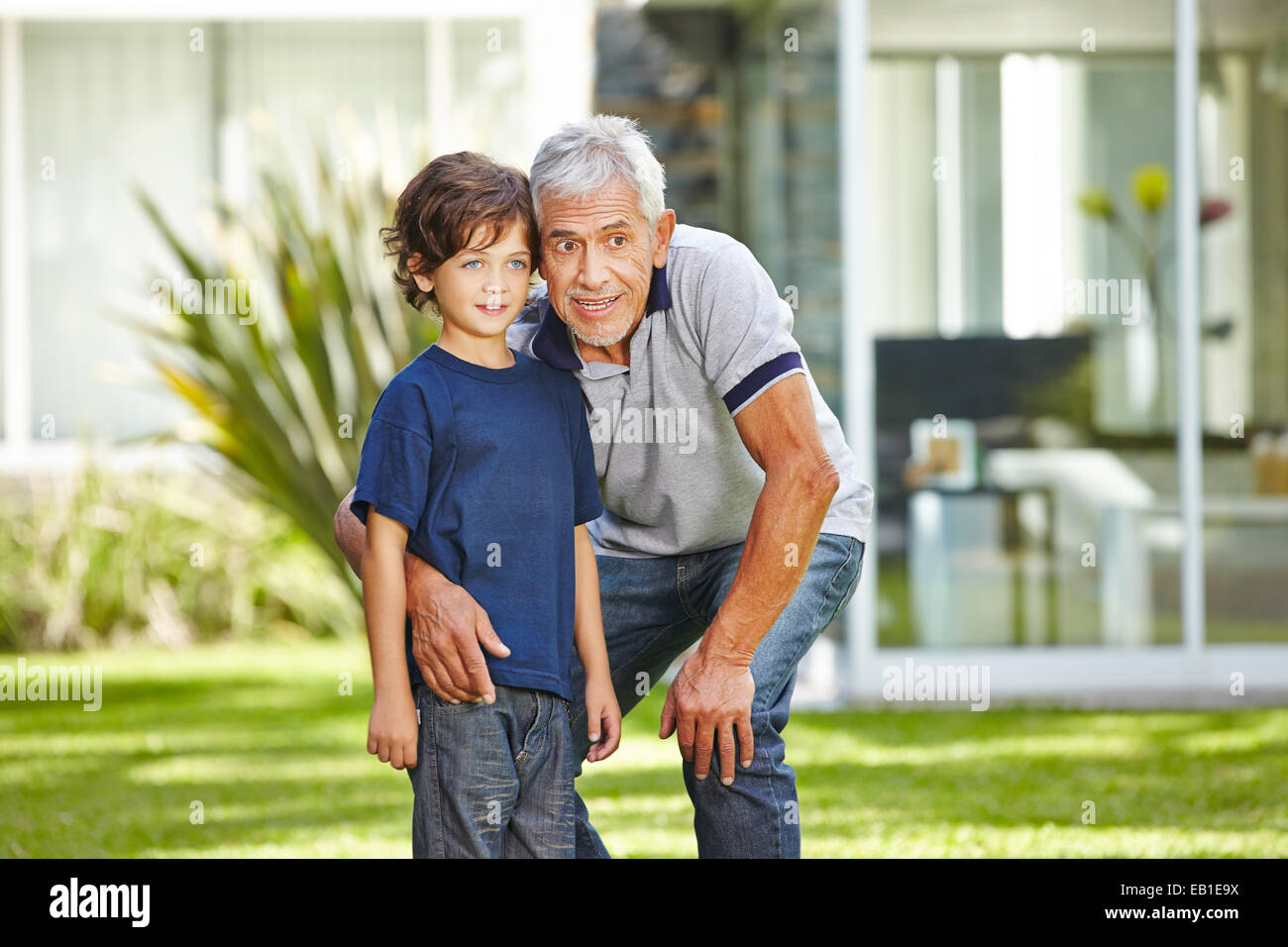 Heureux grand-père parler avec son petit-fils dans un jardin d'été Banque D'Images