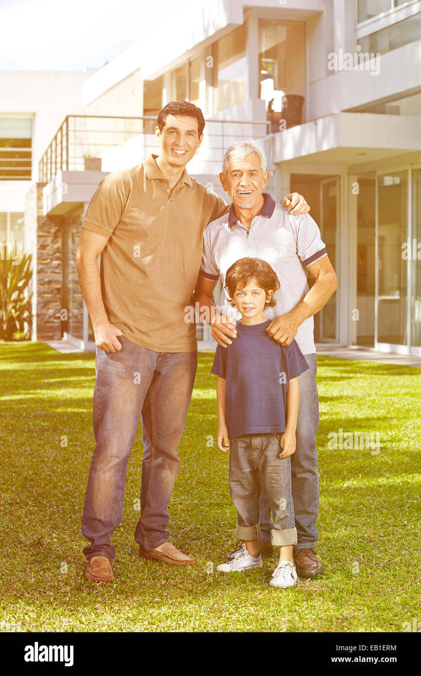 Famille avec grand-père et le petit-enfant en face d'une maison dans le jardin Banque D'Images