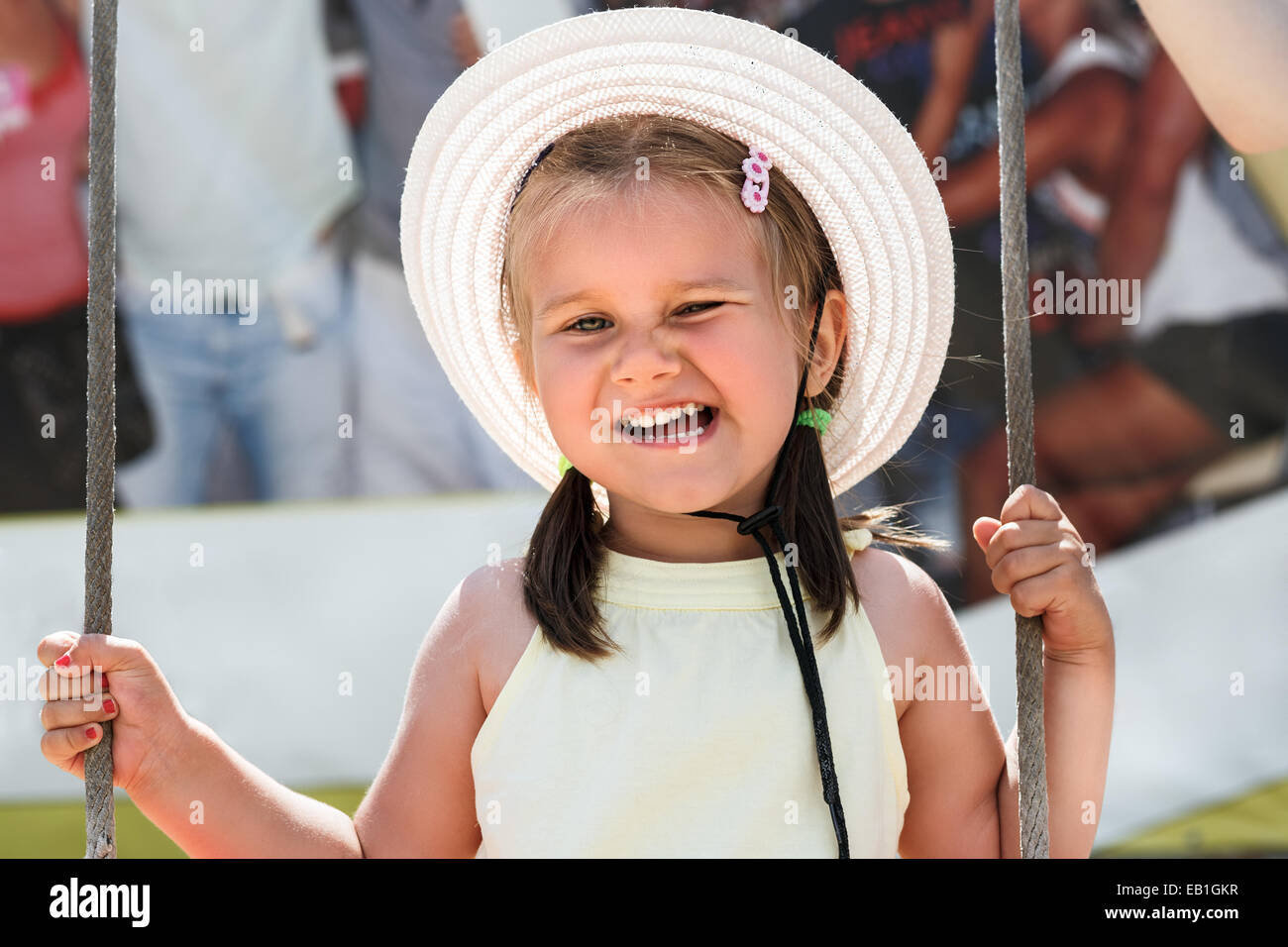 Petite fille dans un hat smiling et clignant de. Profondeur de champ. Banque D'Images