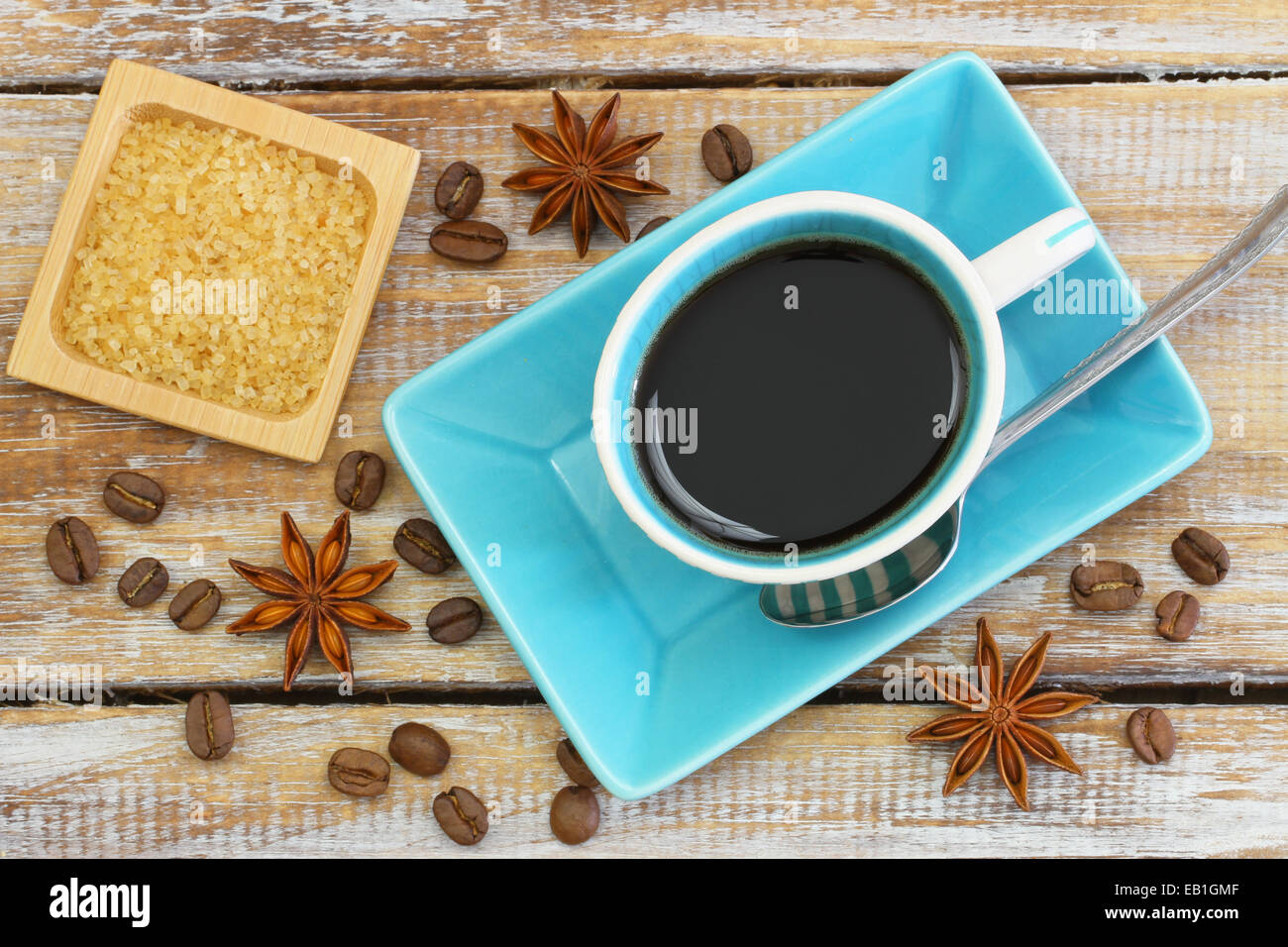 Tasse de café noir, le sucre brun, les grains de café et d'anis étoilé sur la surface en bois rustique Banque D'Images