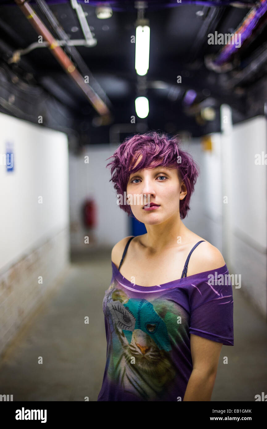 Une jeune adolescente rebelle confiant slim femme aux cheveux violet court  debout dans un sous-sol cave souterraine Photo Stock - Alamy