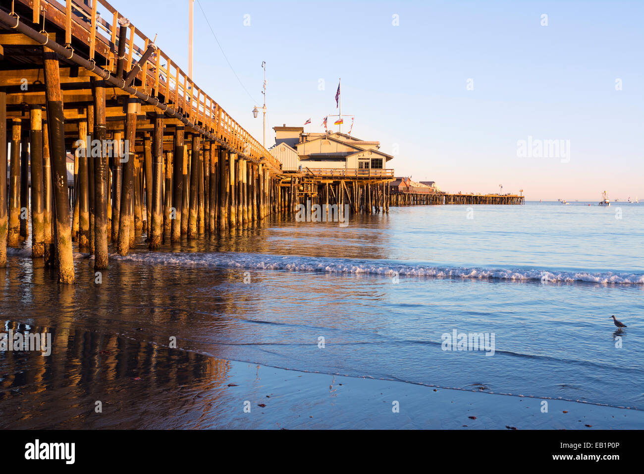 Un bas, Soleil couchant jette une lumière orange profond sur les pieux de la jetée de Santa Barbara, également appelé Stearns Wharf. Banque D'Images