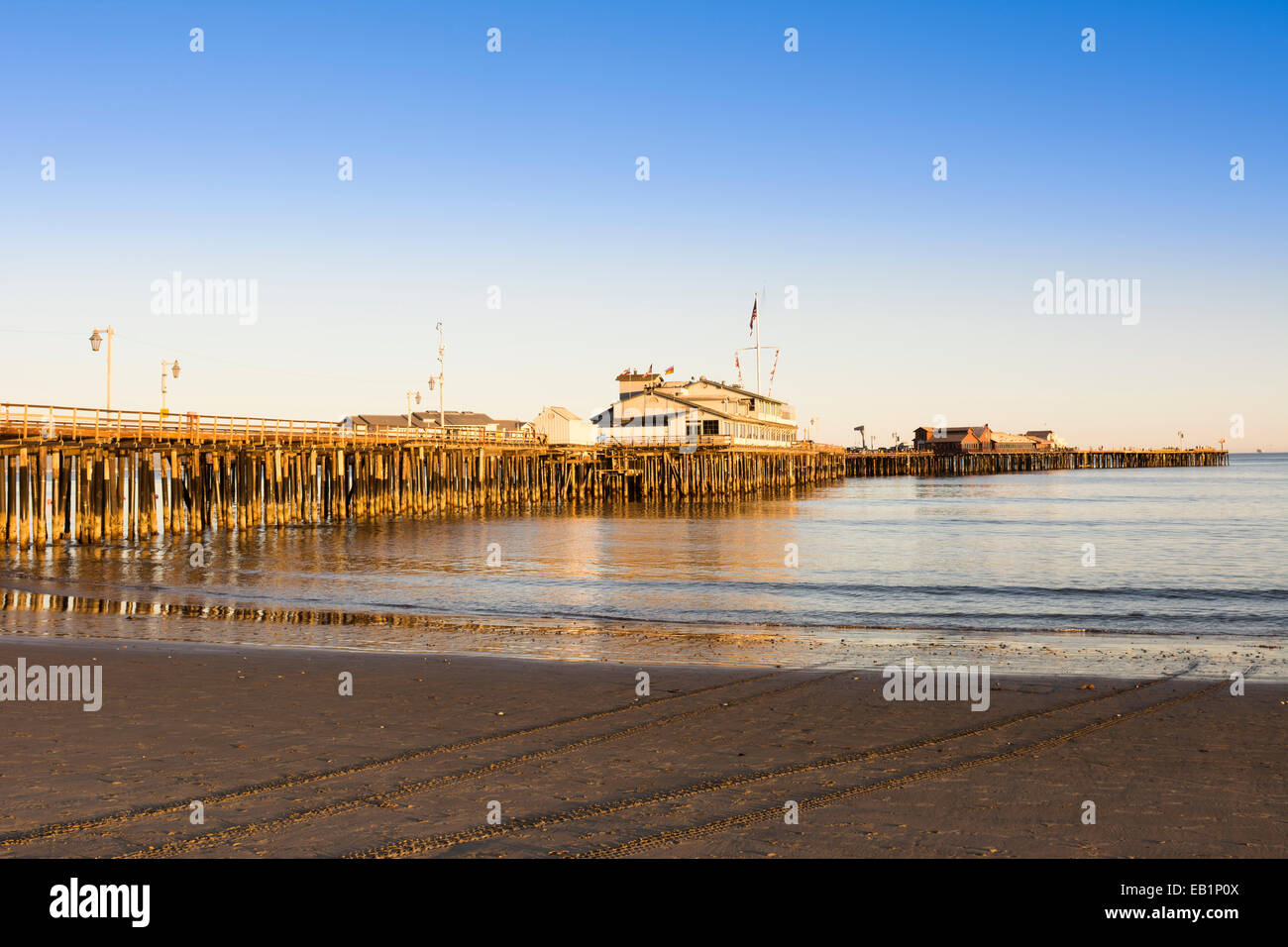 Un bas, Soleil couchant jette une lumière orange profond sur les pieux de la jetée de Santa Barbara, également appelé Stearns Wharf. Banque D'Images