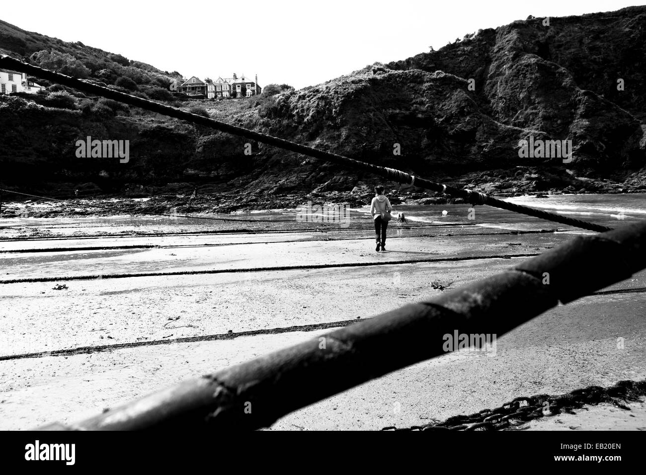 Femme waling à travers des sables bitumineux du port à marée basse Banque D'Images