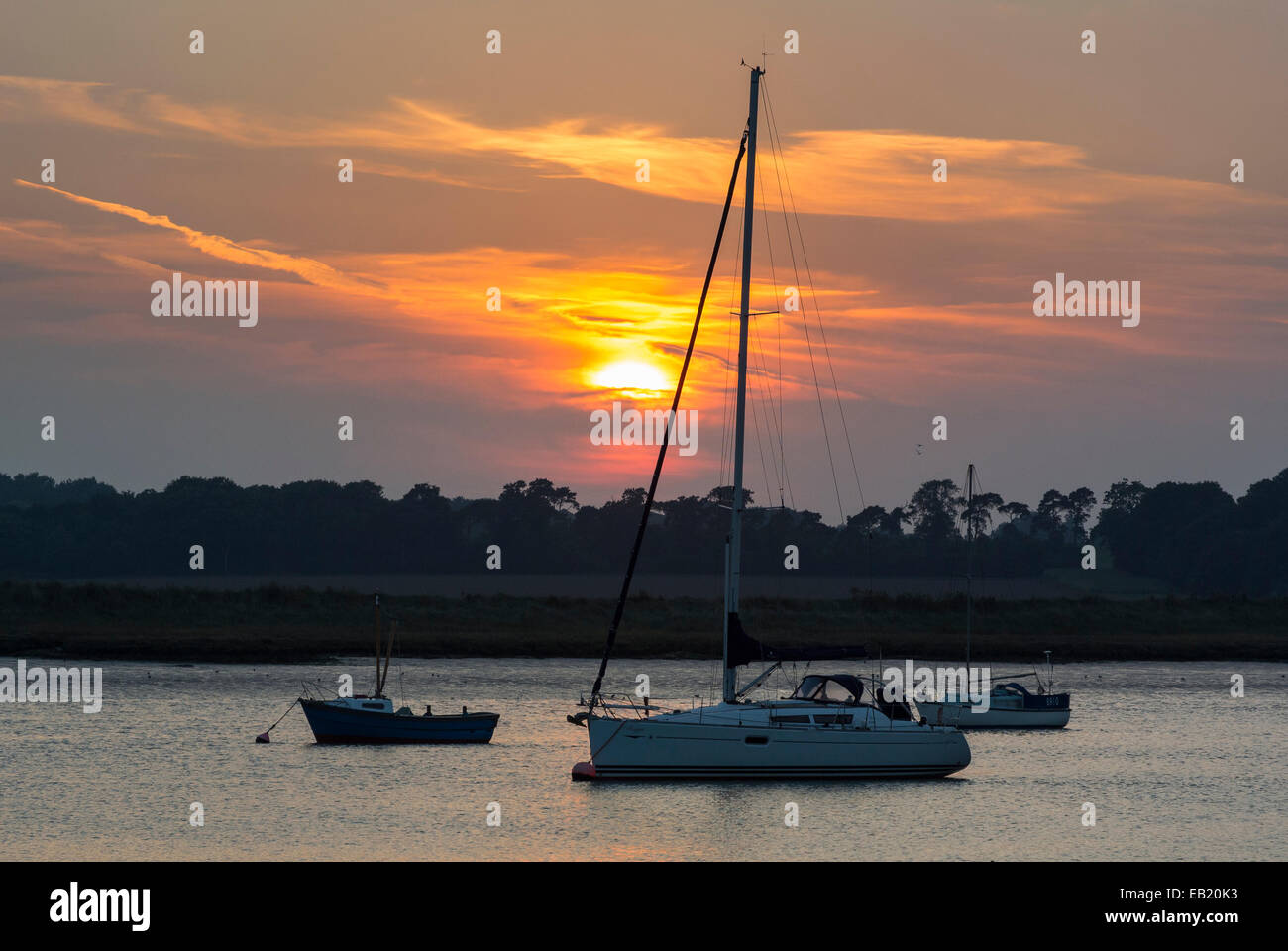 Coucher de soleil sur la rivière Deben avec bateaux à voile amarré à Bawdsey Suffolk Ferry Banque D'Images
