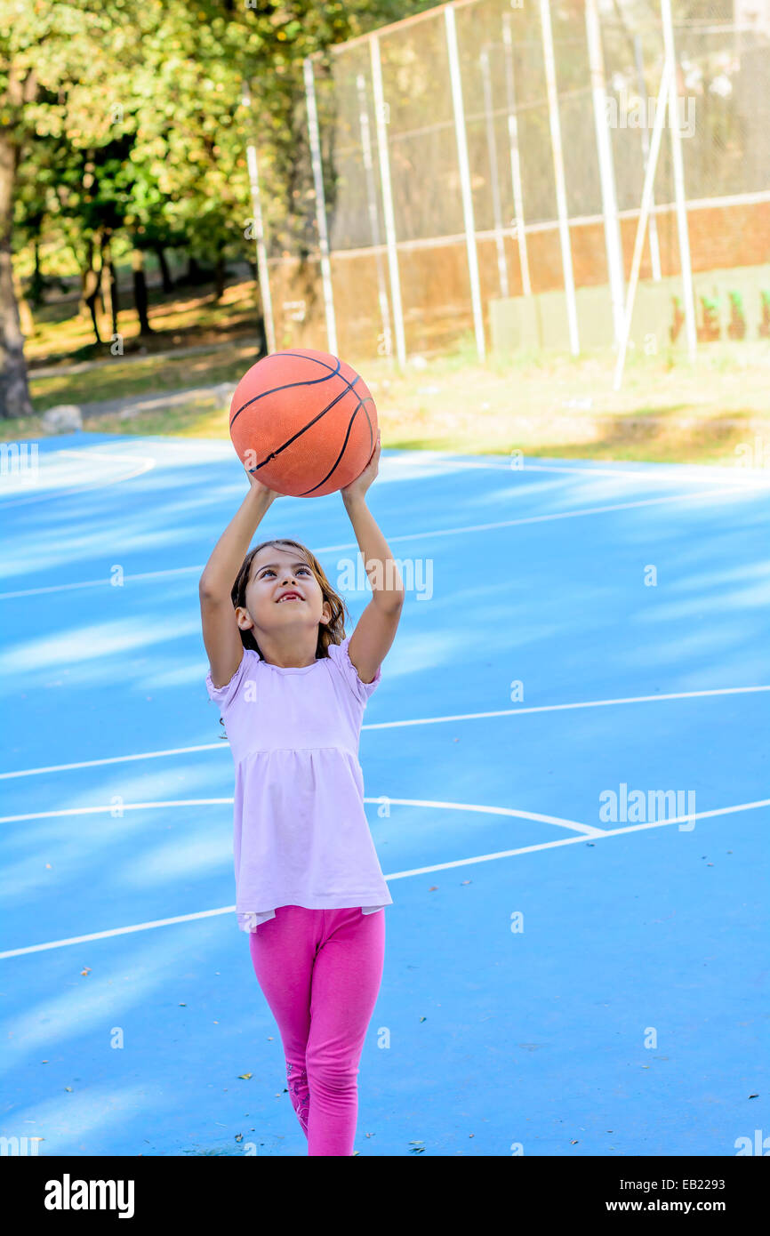 Sept ans, fille, jouer au basket-ball Banque D'Images
