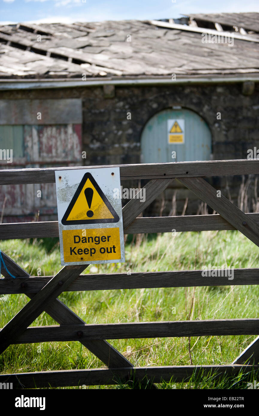Garder hors des signes sur un derlict bâtiment de ferme dans un dangereux état de réparation. Le Lancashire, Royaume-Uni Banque D'Images