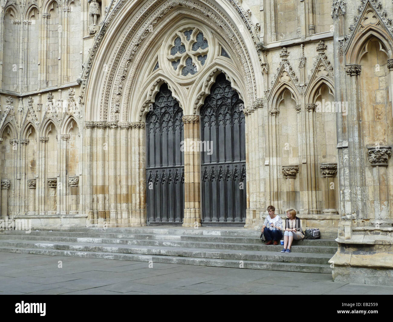 Deux personnes sont assises sur les marches de la cathédrale de York. Banque D'Images