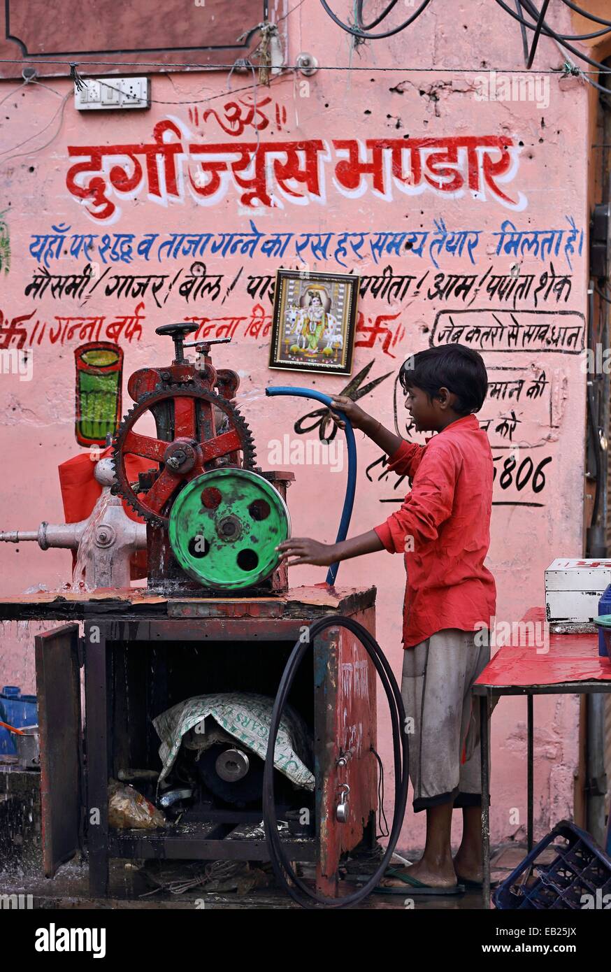Jeune garçon indien un nettoyage machine à jus de canne à sucre en Inde Banque D'Images
