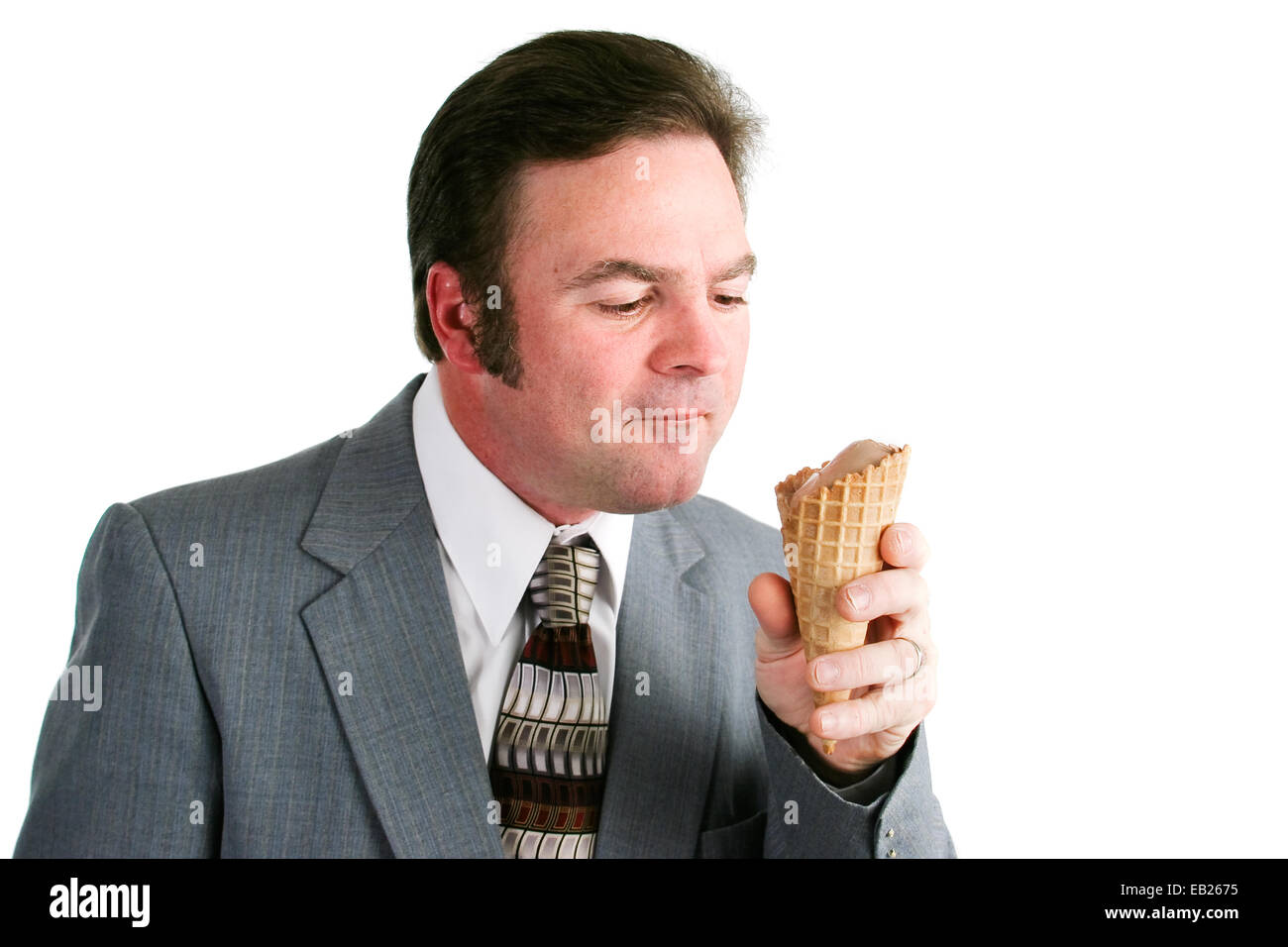 L'homme en costume de manger une glace au cornet gaufré. Isolé sur fond blanc Banque D'Images