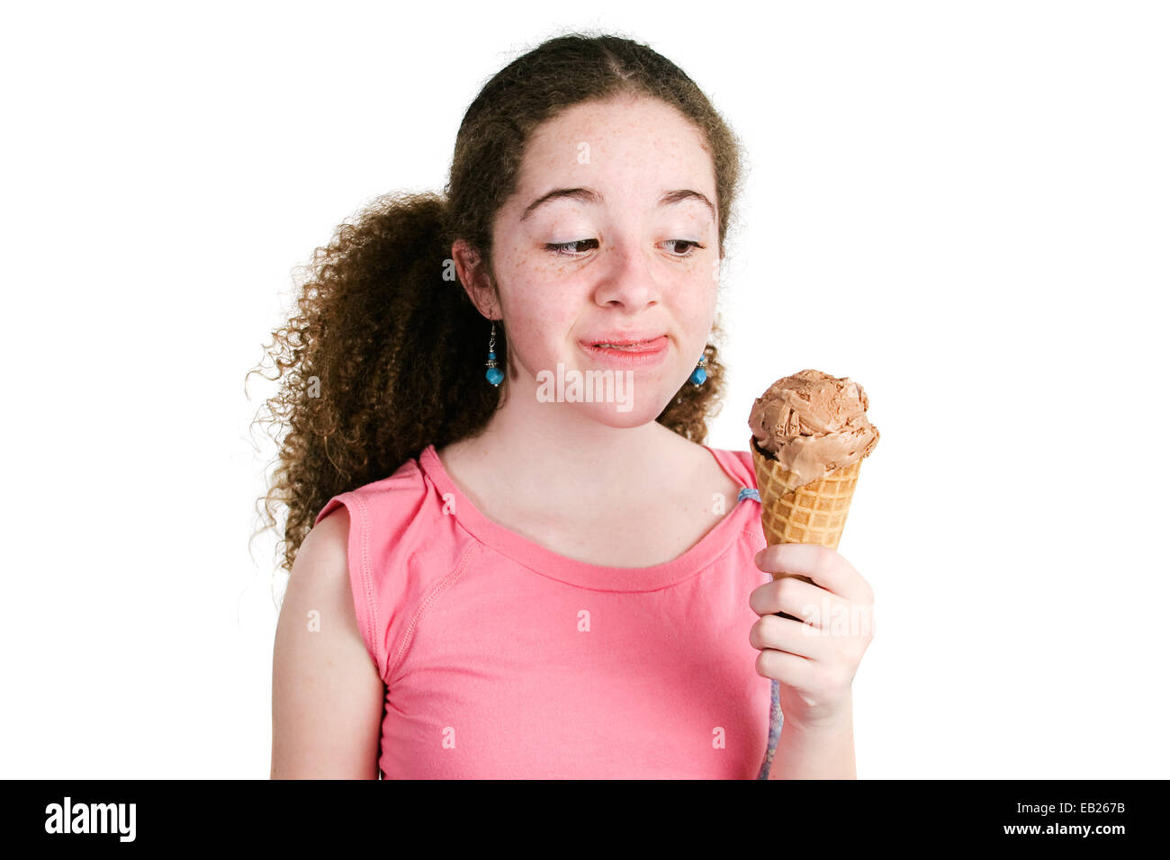 Fille de latina adolescents avec des cheveux bouclés et rousseur tenant un cornet de crème glacée au chocolat délicieux et convertible dans ant Banque D'Images