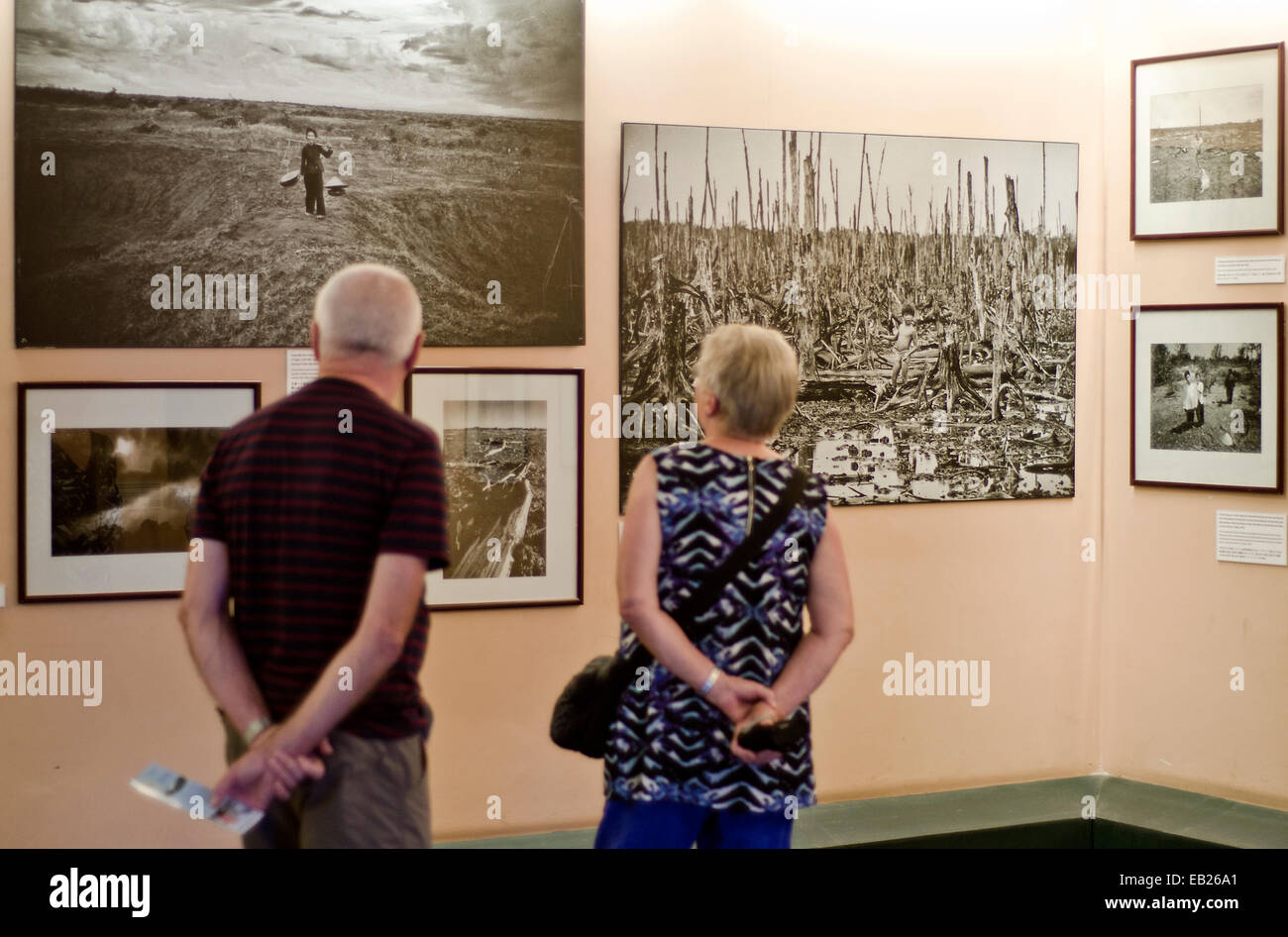 Les touristes à la recherche de photos de forêt défoliés par l'agent orange au Musée des débris de guerre à Ho Chi Minh, Vietnam Banque D'Images