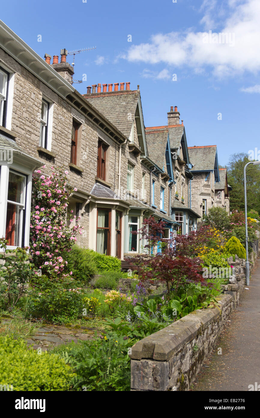 Grande terrasse de maisons mitoyennes de style victorien d'une zone de conservation de Kendal, Cumbria Lake District. Jardins avec la plantation dominé par des arbustes. Banque D'Images