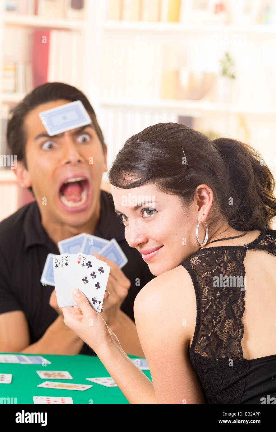 Young couple playing cards cuarenta Banque D'Images