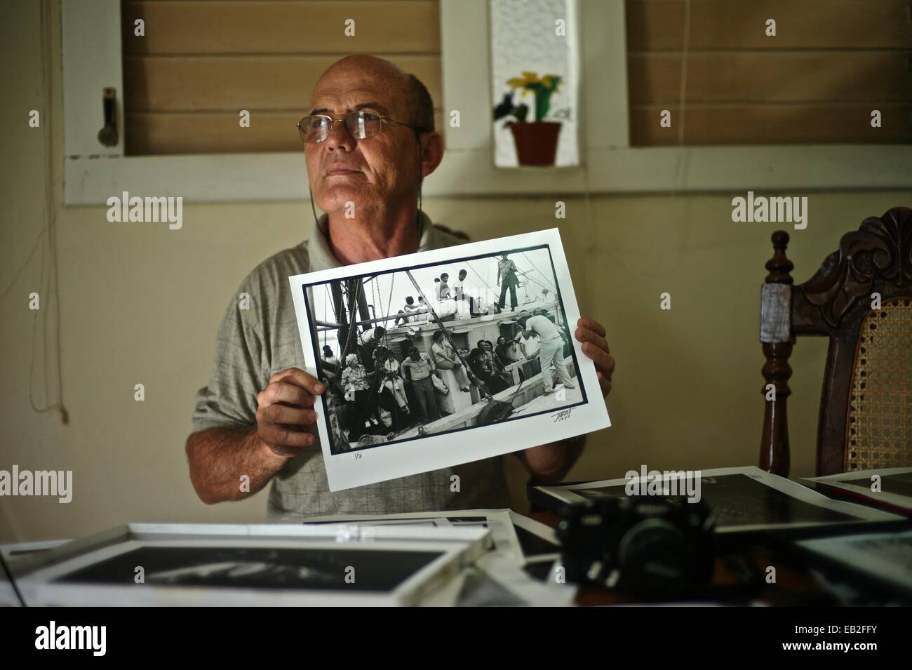 Photographe cubain José Marti, tenant une photo de l'Mariel boatlift, à son domicile de La Havane. Banque D'Images