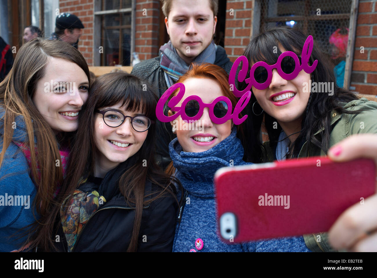 Les adolescents en tenant vos autoportraits lui-même avec des lunettes fashion rose Cool. Musique, danse, costumes et parti à Binche Carnaval. Ancienne Banque D'Images
