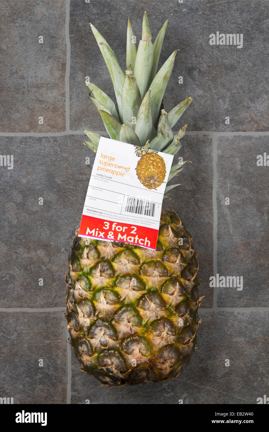 Supermarché 3 pour 2 offre Mix & Match sur un ananas sur un sol dallé Banque D'Images