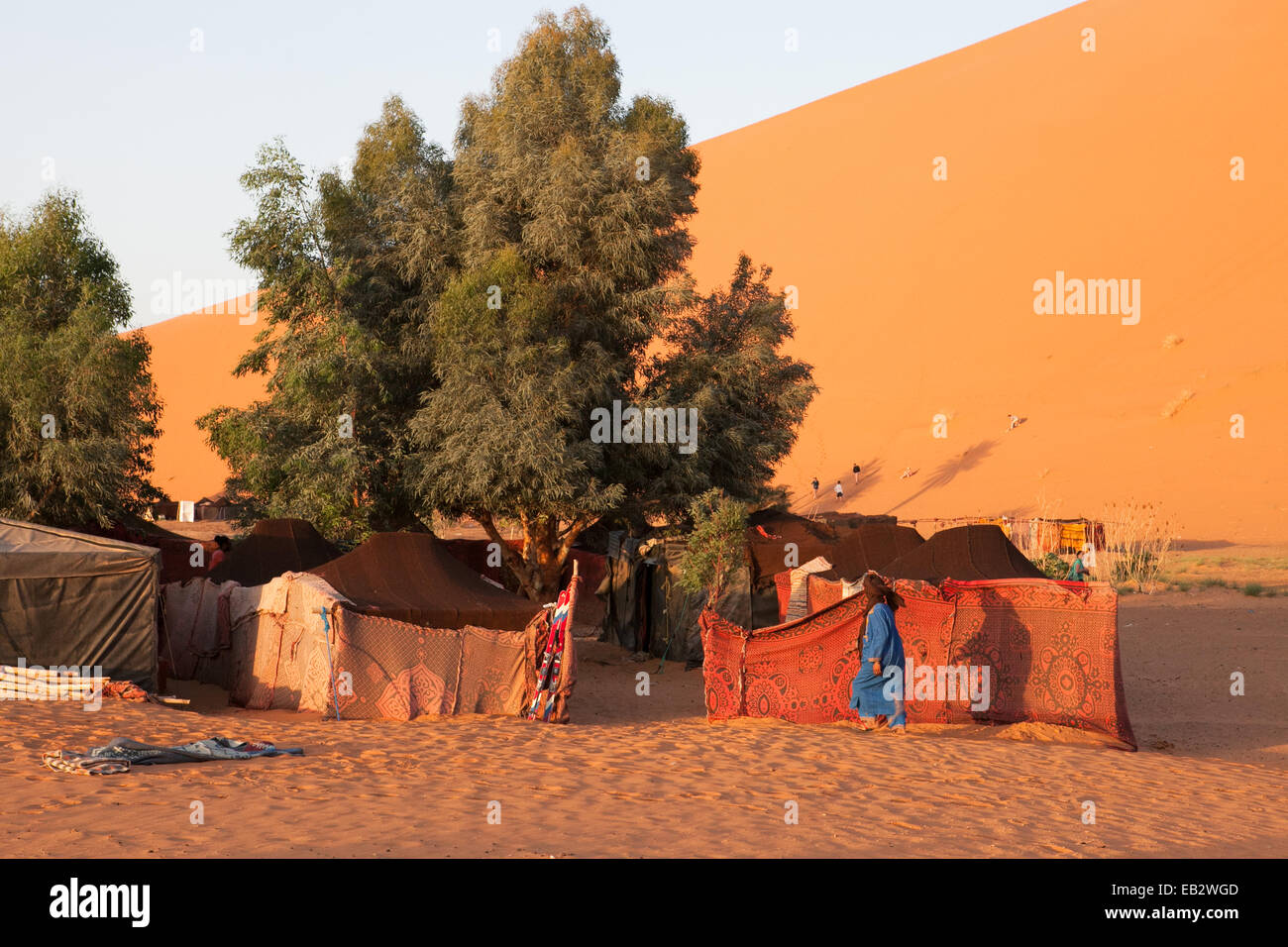 Un homme marche entre un camp de tentes situé dans le désert du Sahara. Banque D'Images