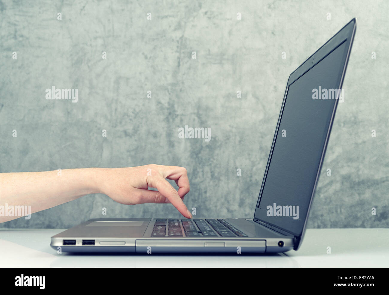 Caucasian Woman en appuyant sur le bouton sur le clavier de l'ordinateur portable. Banque D'Images