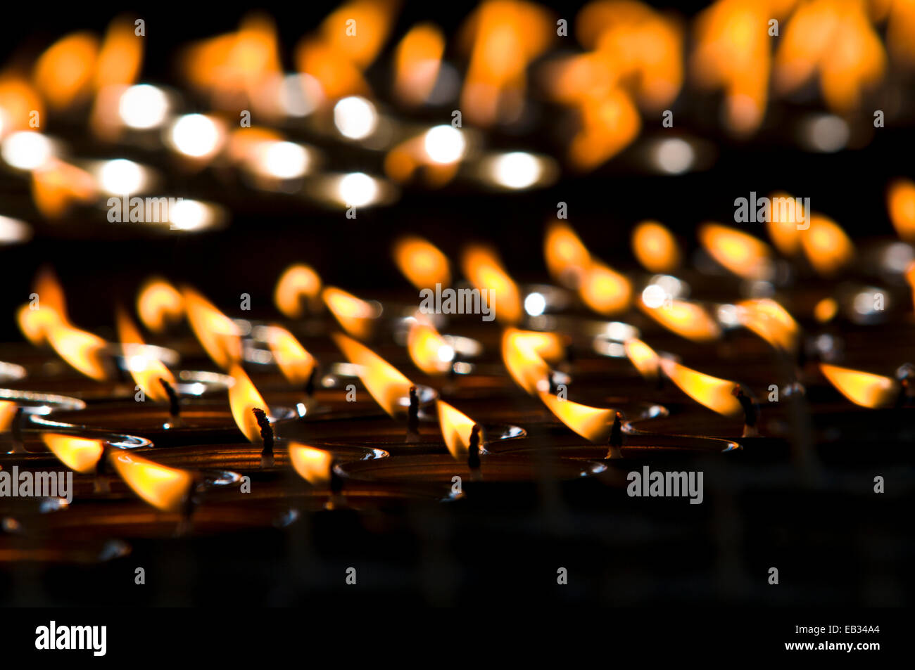 Flammes brûler dans des rangées de lampes à beurre pour les prières et les aspirations à l'Thimphu Memorial chorten. Banque D'Images