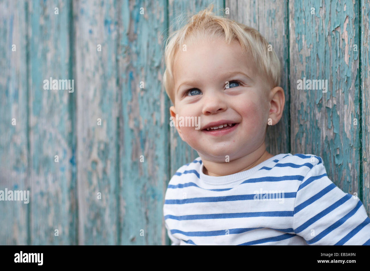Portrait of boy leaning against wall en bois Banque D'Images