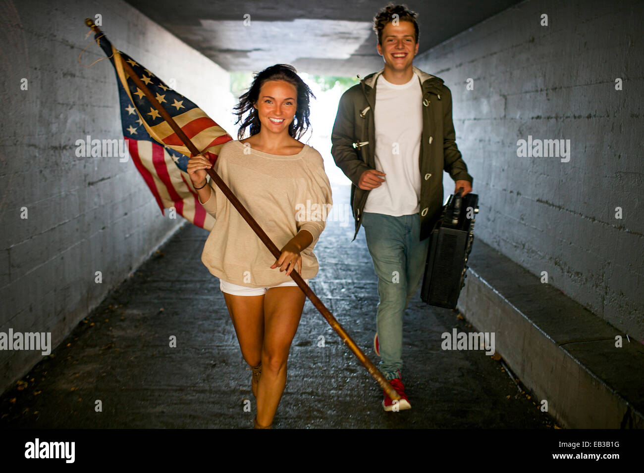 Caucasian couple exerçant son drapeau américain et de flèche fort dans le tunnel Banque D'Images