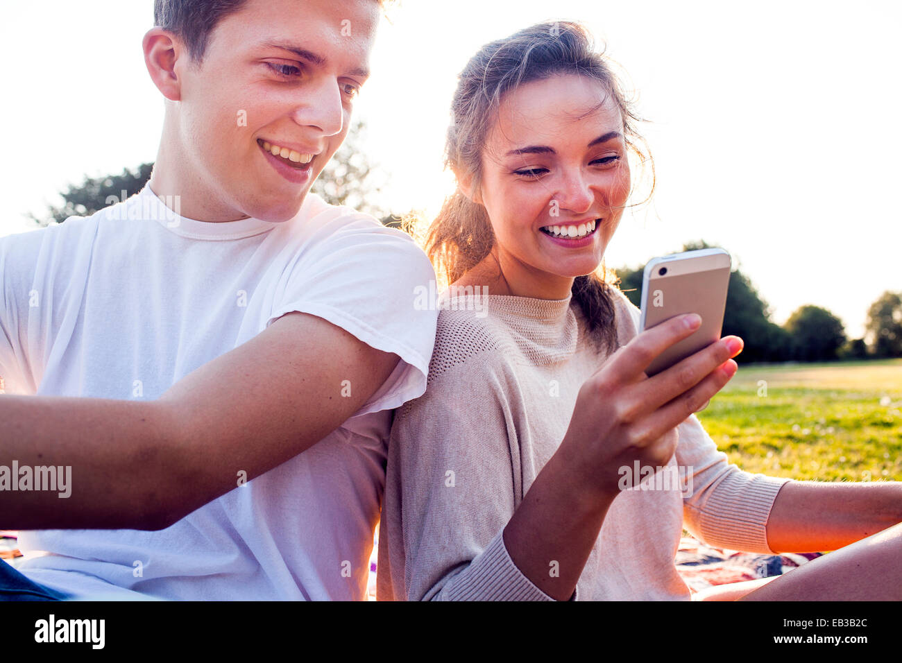 Caucasian couple using cell phone outdoors Banque D'Images