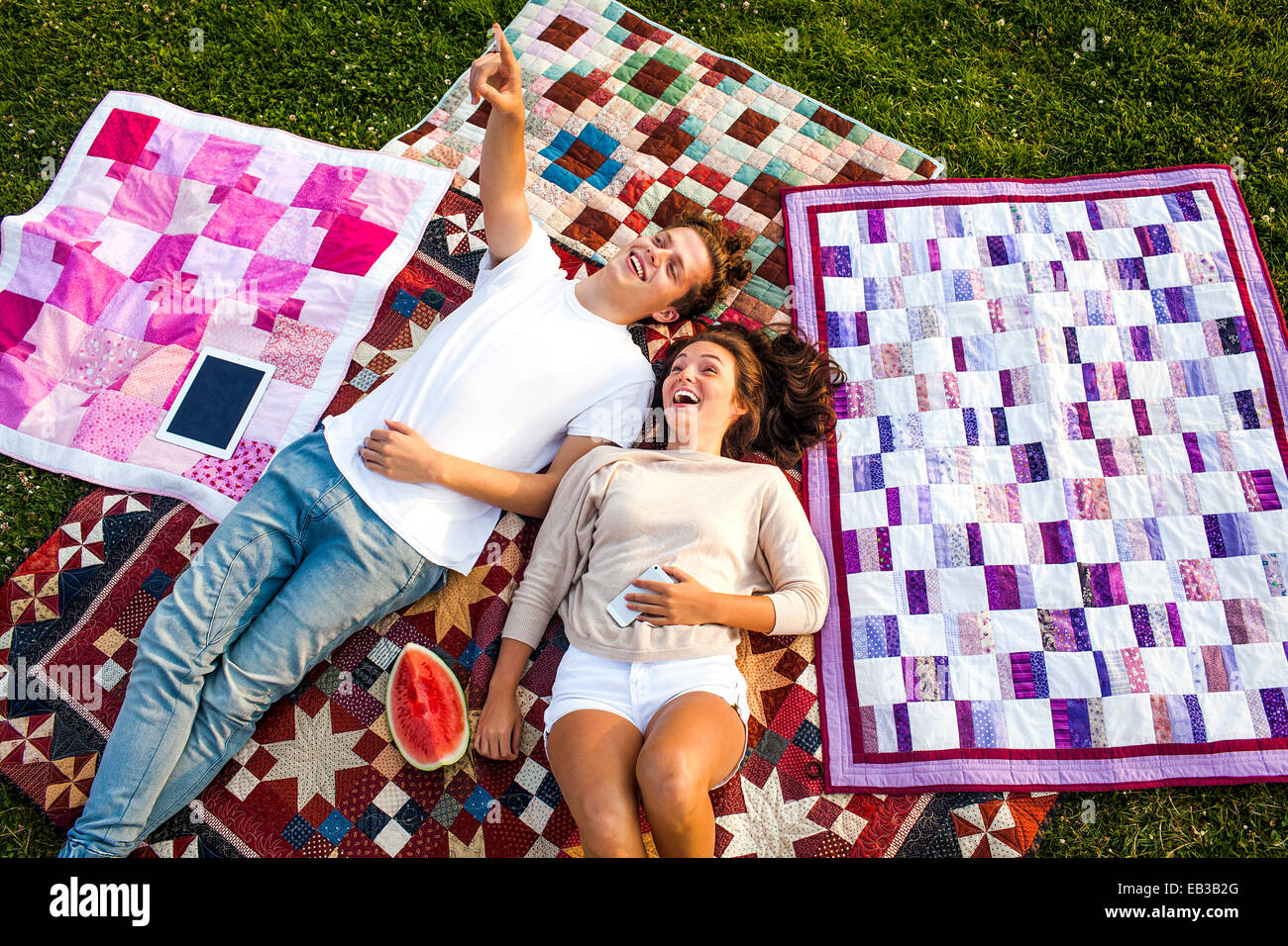 Couple de détente sur des couvertures dans park Banque D'Images