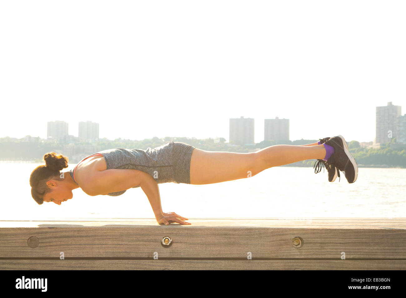 Mixed Race woman exercising at urban waterfront Banque D'Images