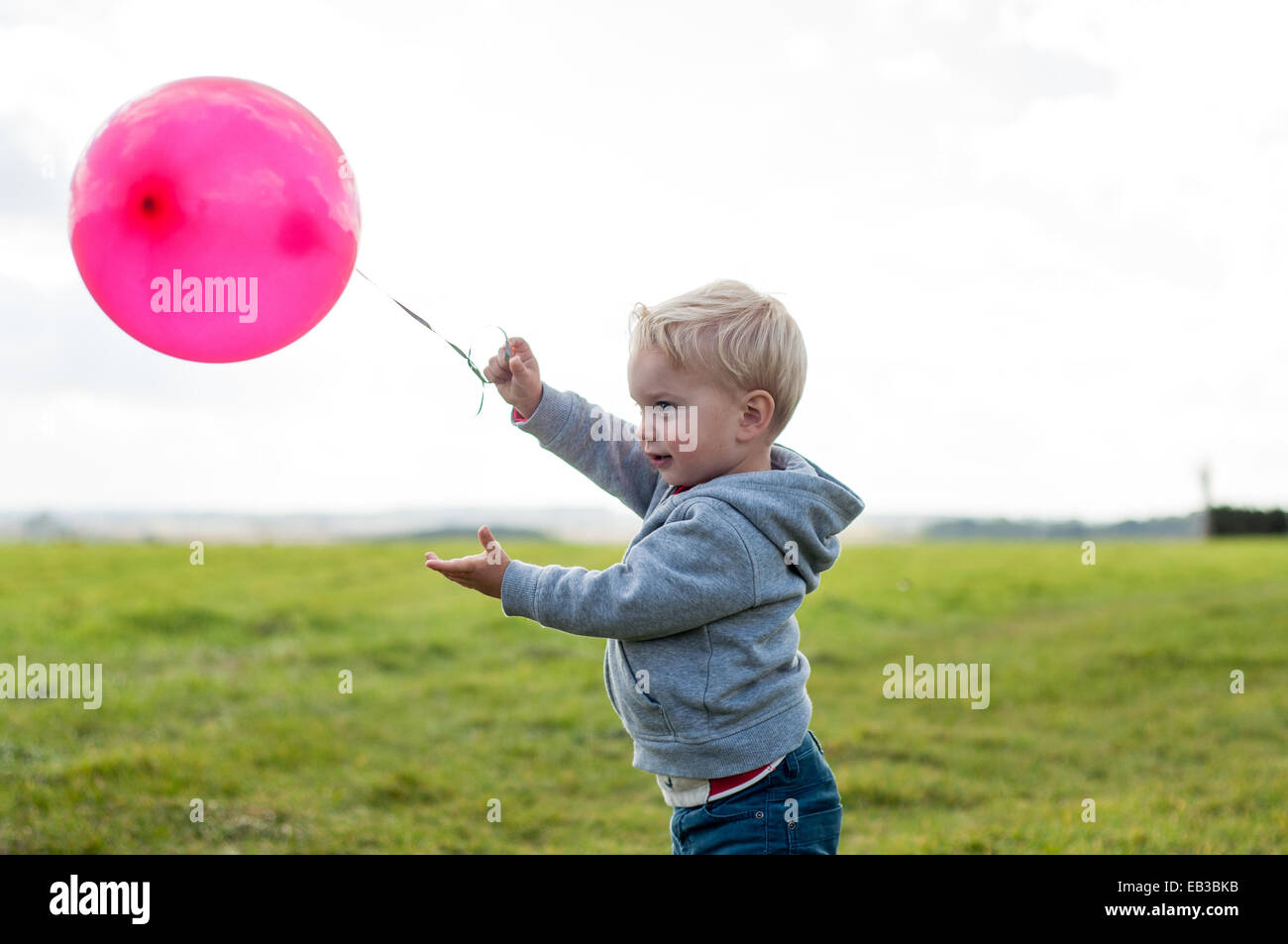 Boy standing in a field balloon Banque D'Images