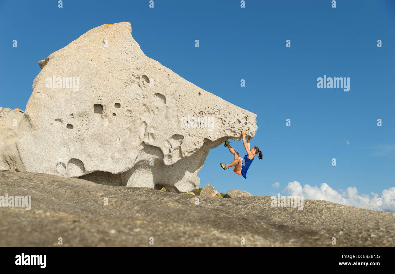 France, Corse, femme l'escalade sur le seul gros rock Banque D'Images