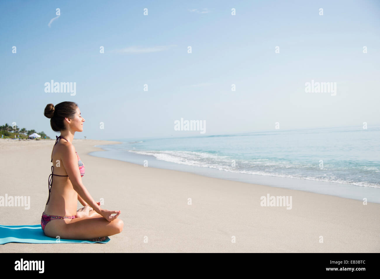 Caucasian woman meditating on beach Banque D'Images