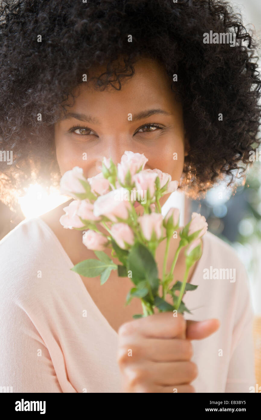 Woman smelling bouquet de roses à l'intérieur Banque D'Images