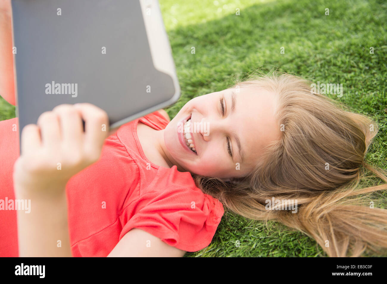 Woman using digital tablet sur pelouse Banque D'Images