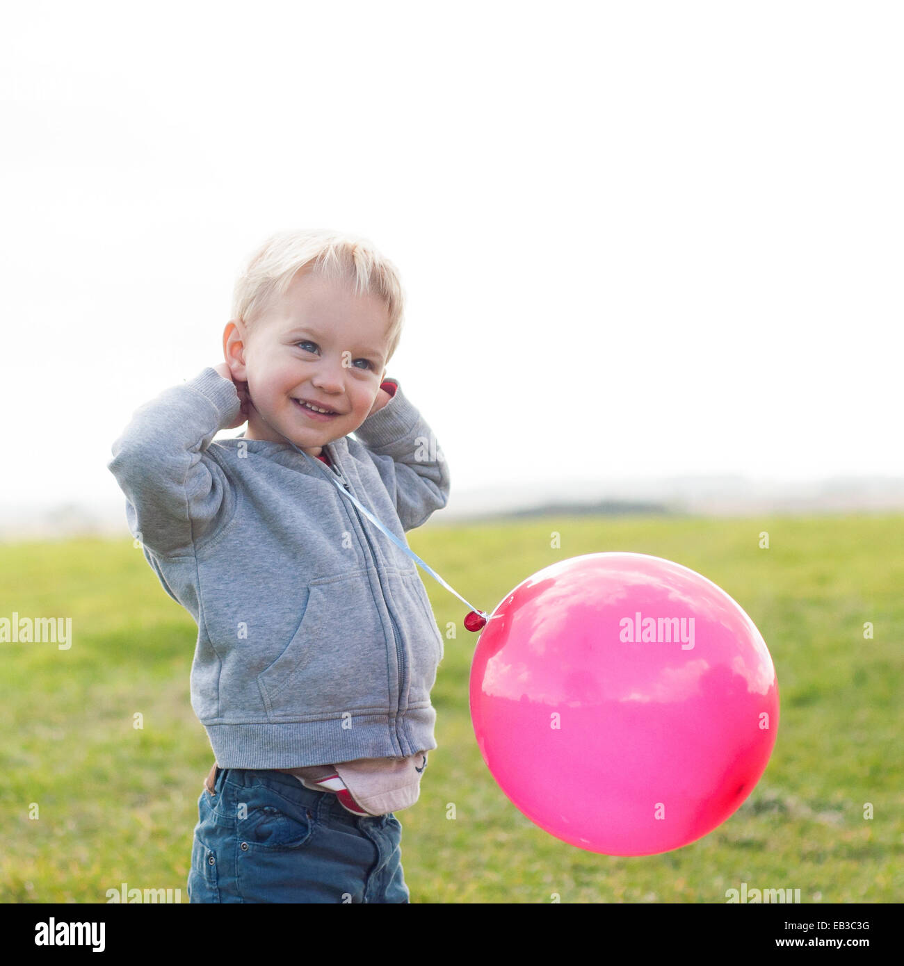 Boy holding a pink balloon Banque D'Images