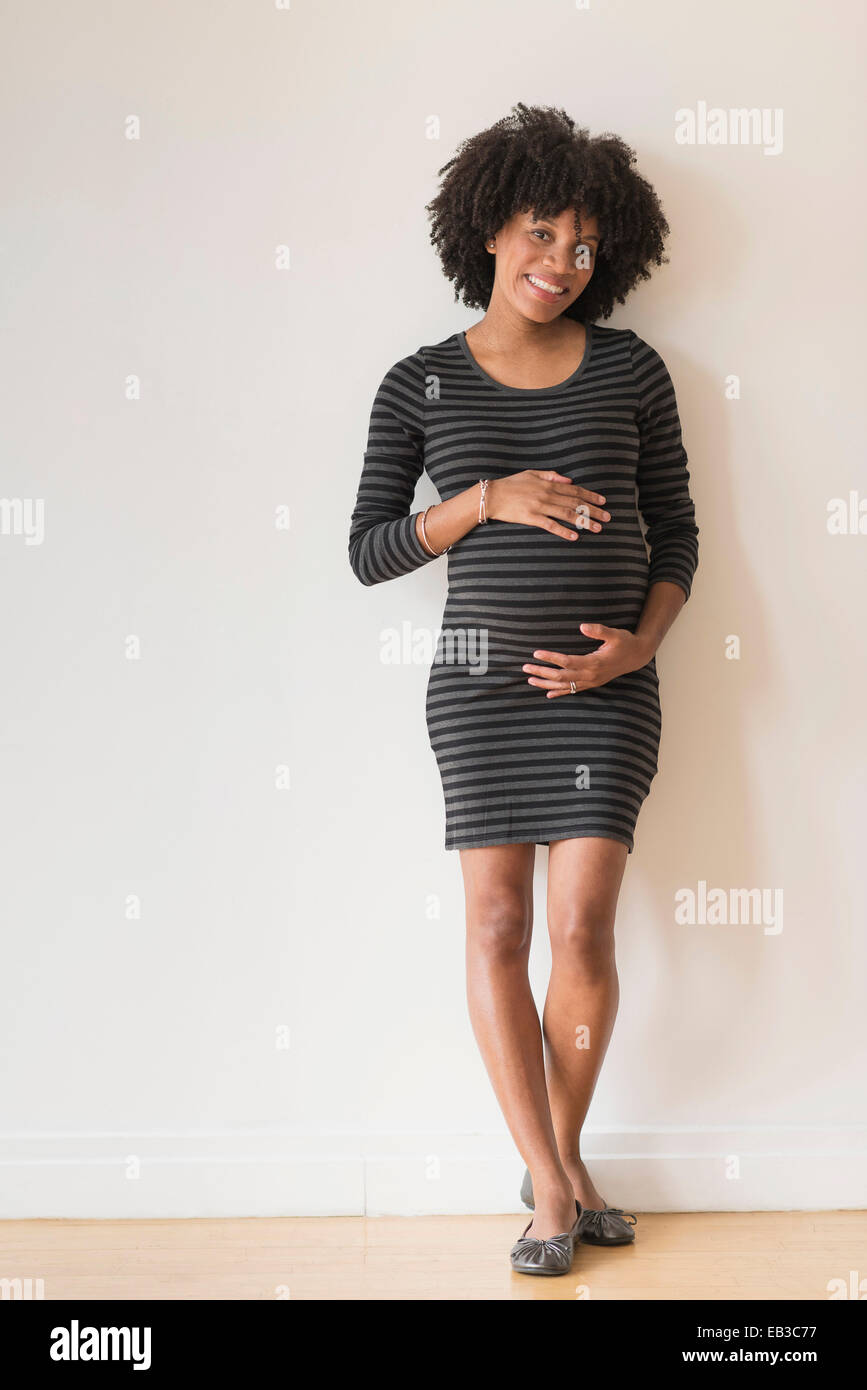 Pregnant African American mother holding sa Banque D'Images