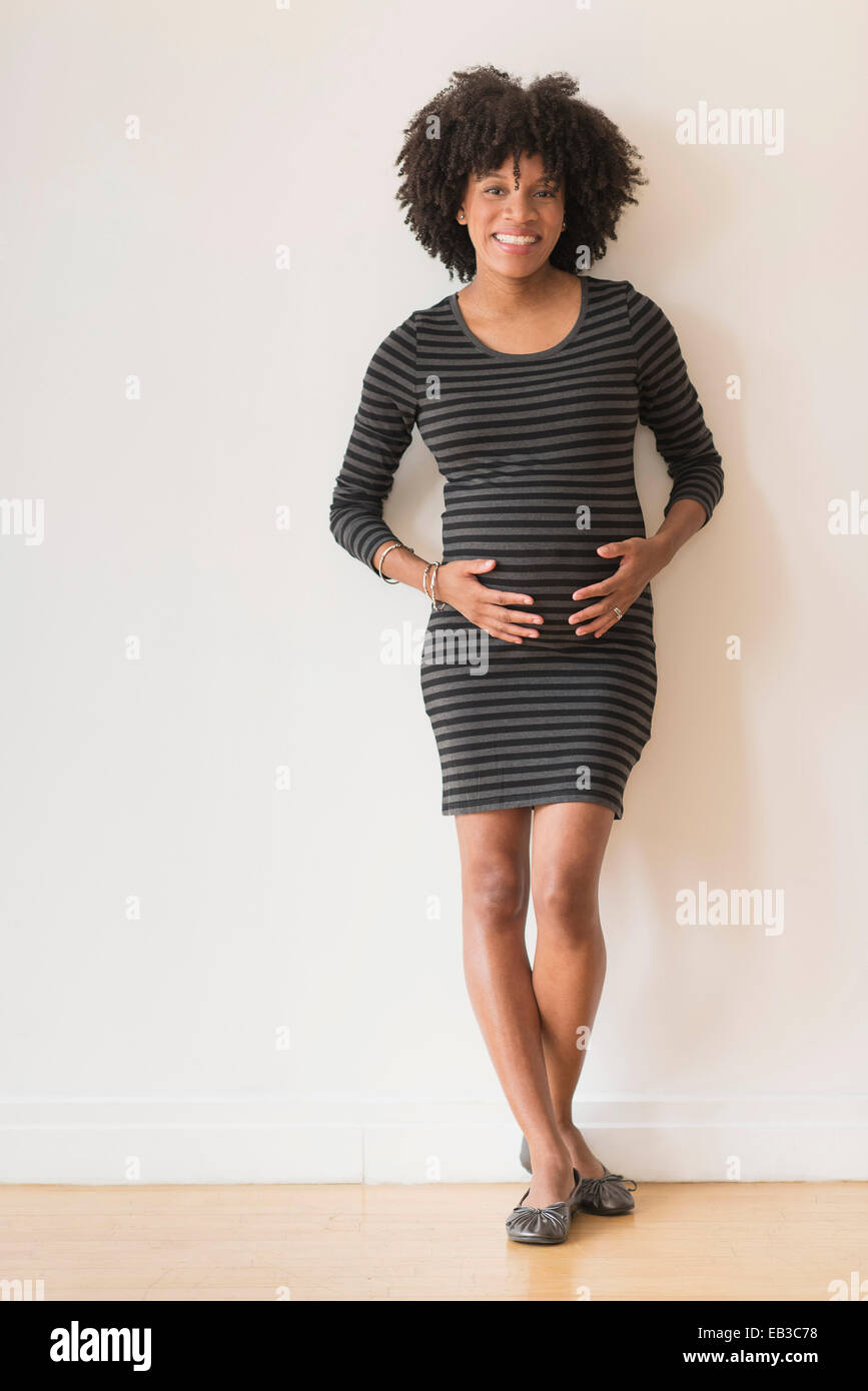 Pregnant African American mother holding sa Banque D'Images