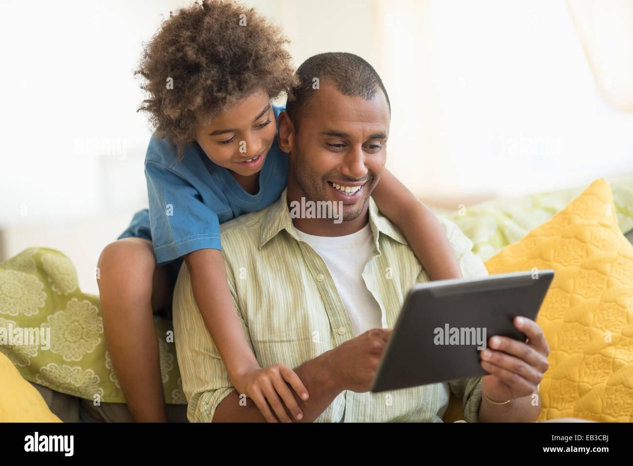 Père et fils using digital tablet together in living room Banque D'Images