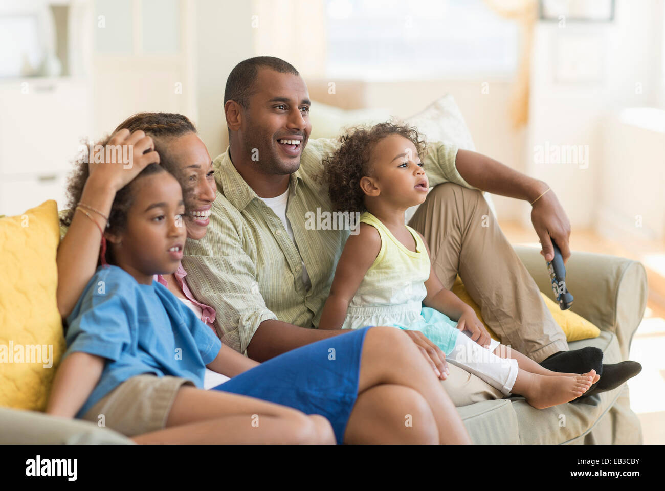 Famille regardent la télévision ensemble dans la salle de séjour Banque D'Images