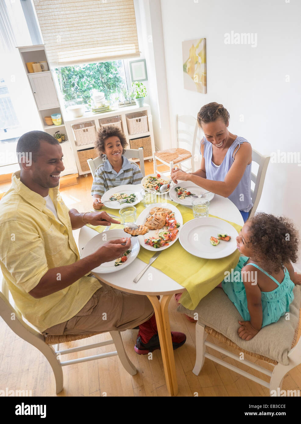 Mixed Race family eating at table de salle à manger Banque D'Images