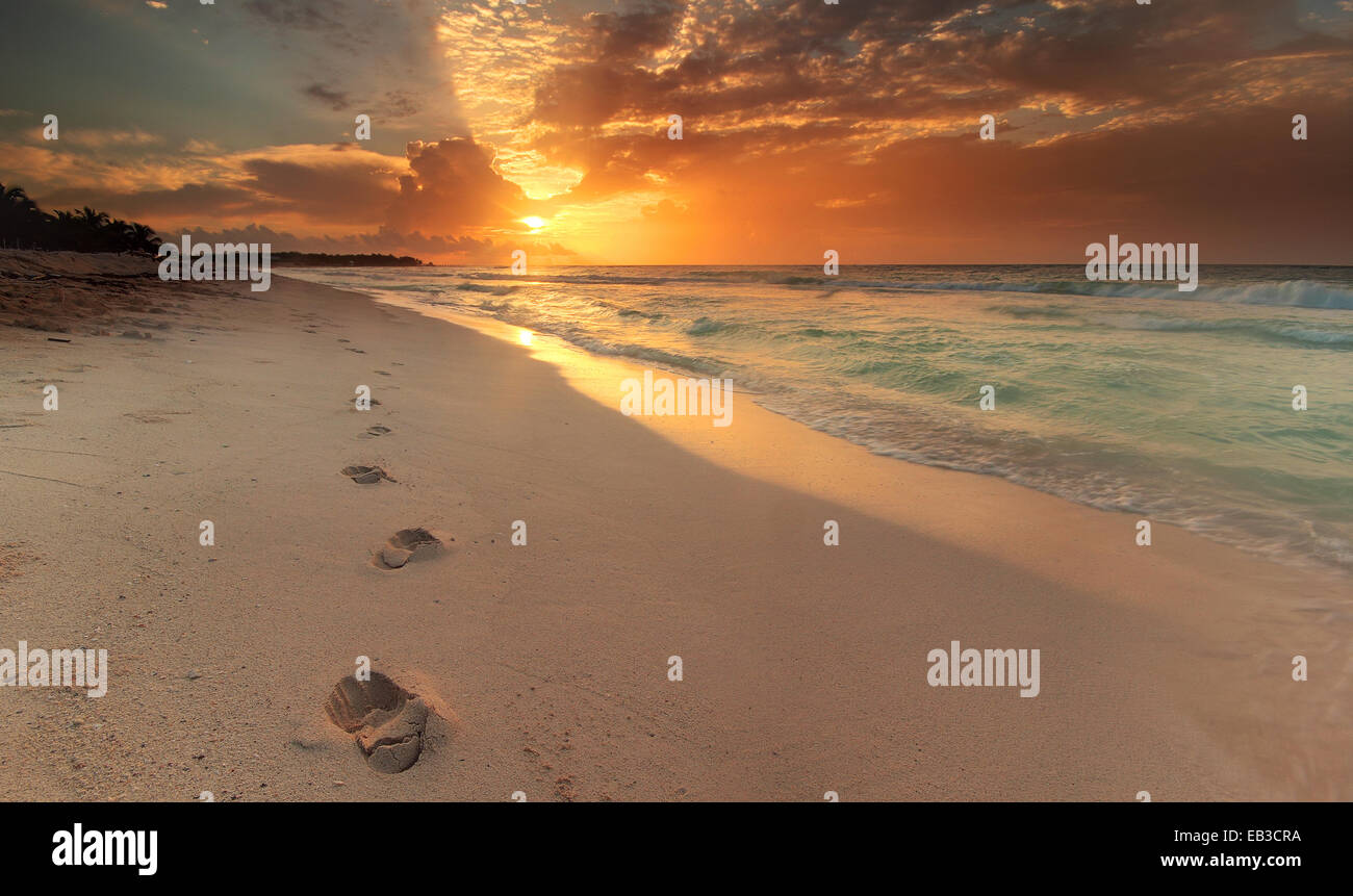 Riviera Maya, Mexique, Akumal Beach, le long de la côte, avec des empreintes de pas dans le sable au lever du soleil Banque D'Images