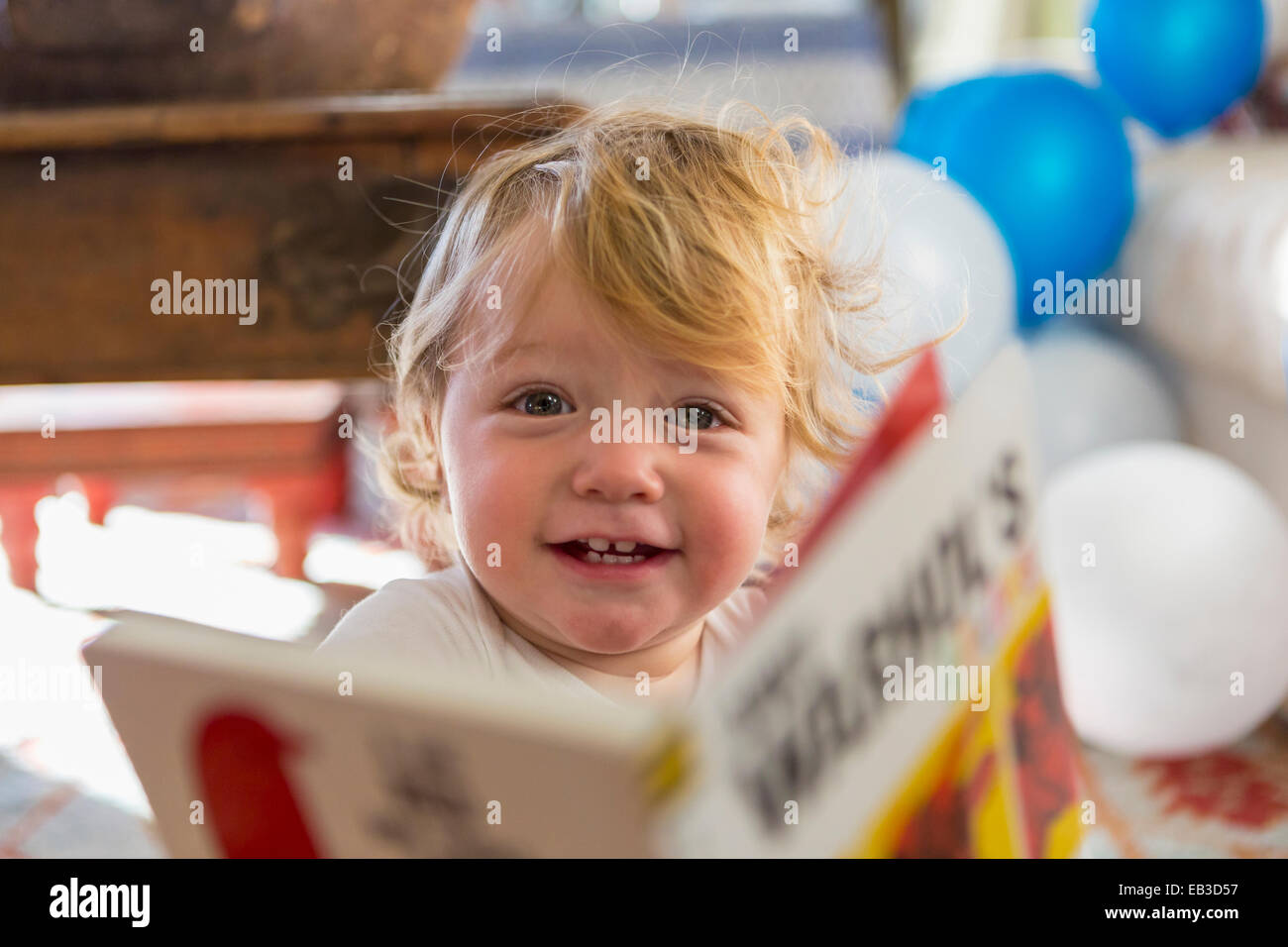 Caucasian baby boy playing with book Banque D'Images