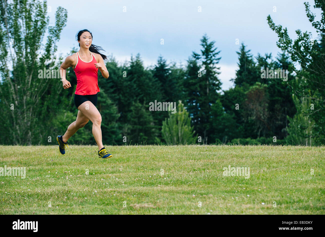 Korean woman running in field Banque D'Images