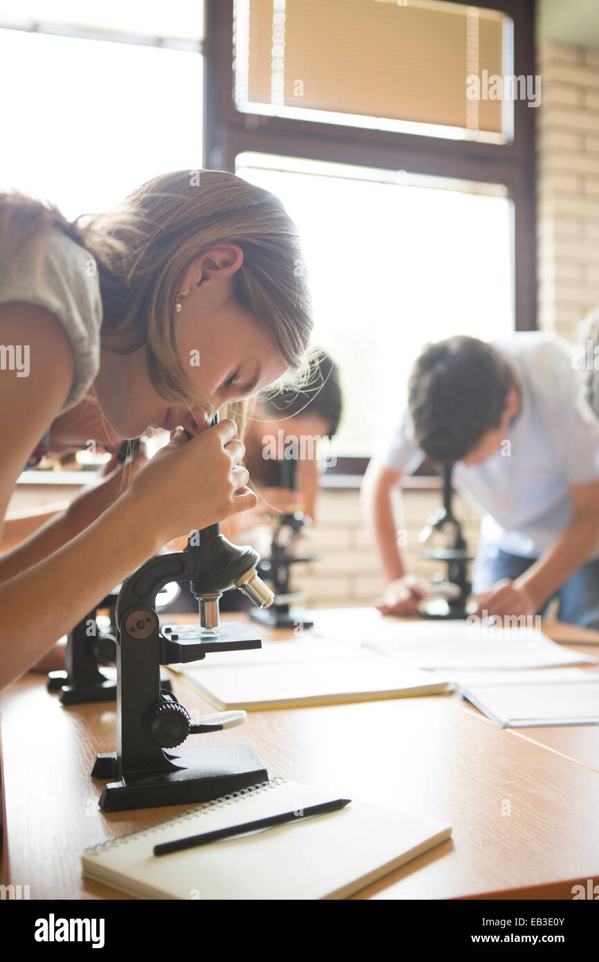 Les élèves à l'aide de microscopes en classe de sciences Banque D'Images