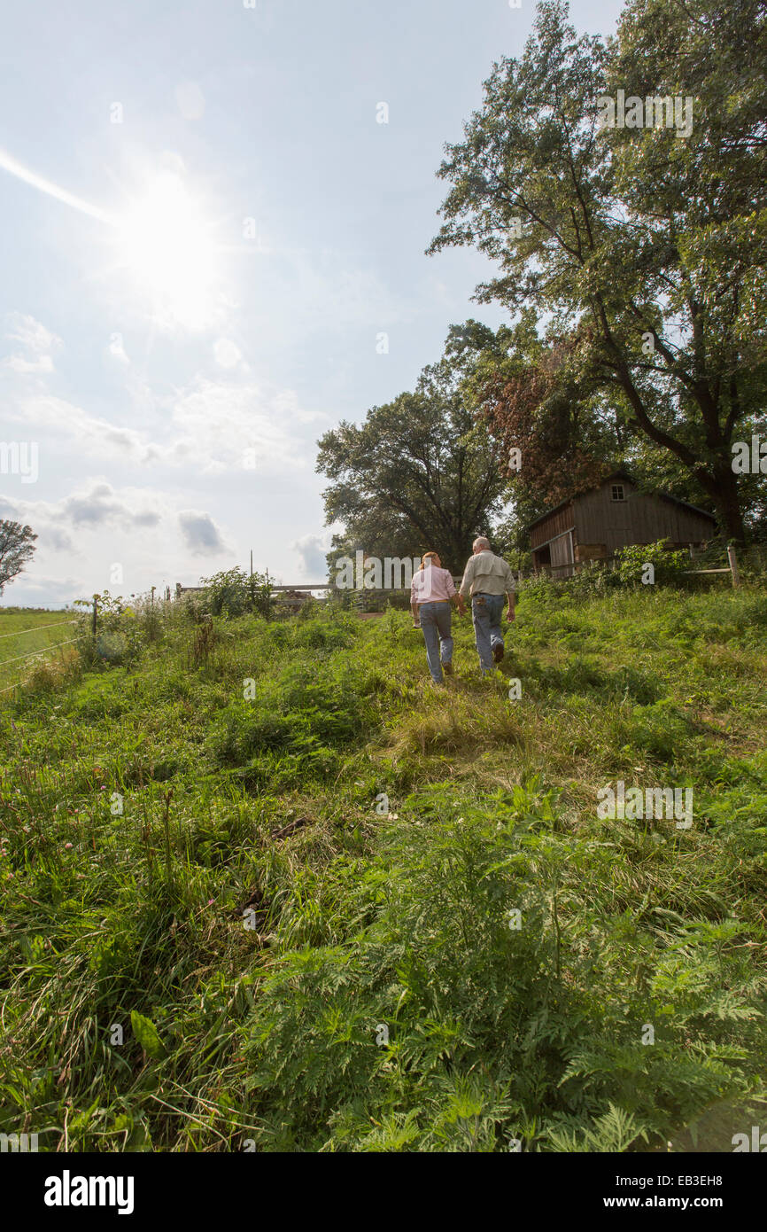 Caucasian couple walking on farm Banque D'Images