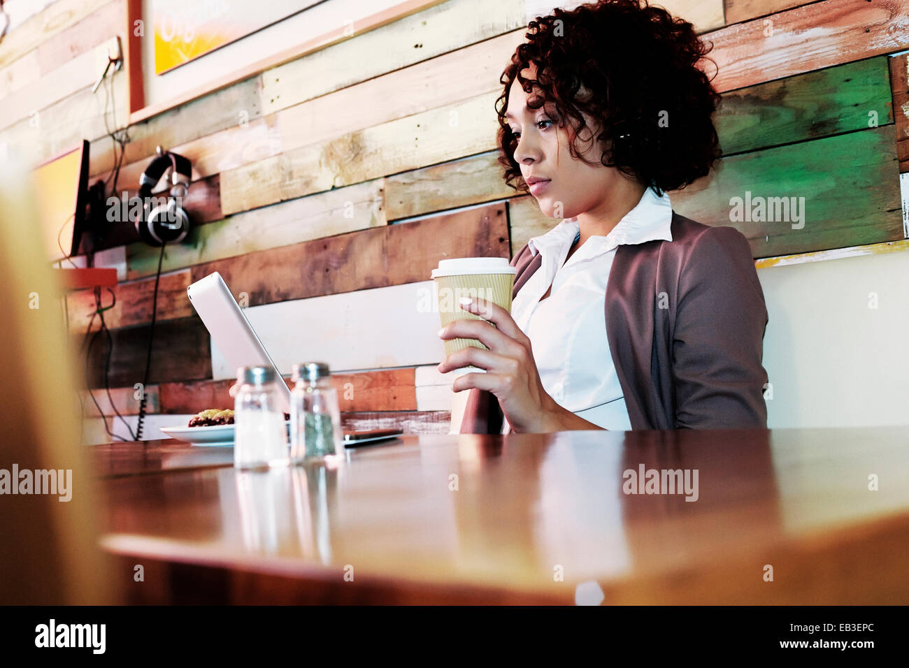 Mixed Race businesswoman using laptop in cafe Banque D'Images