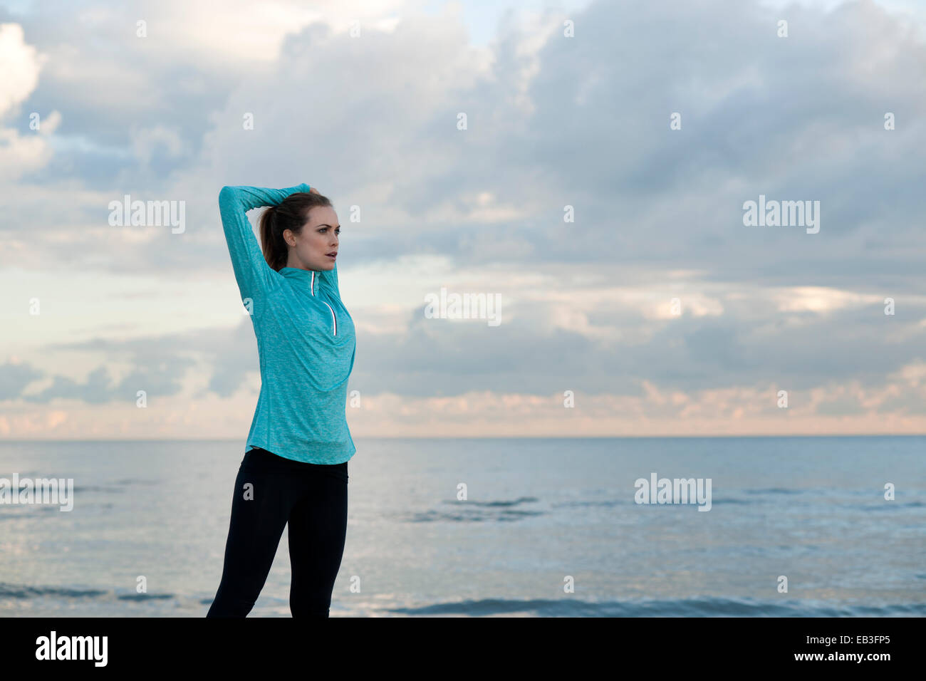 Young woman stretching et l'exercice par la mer Banque D'Images