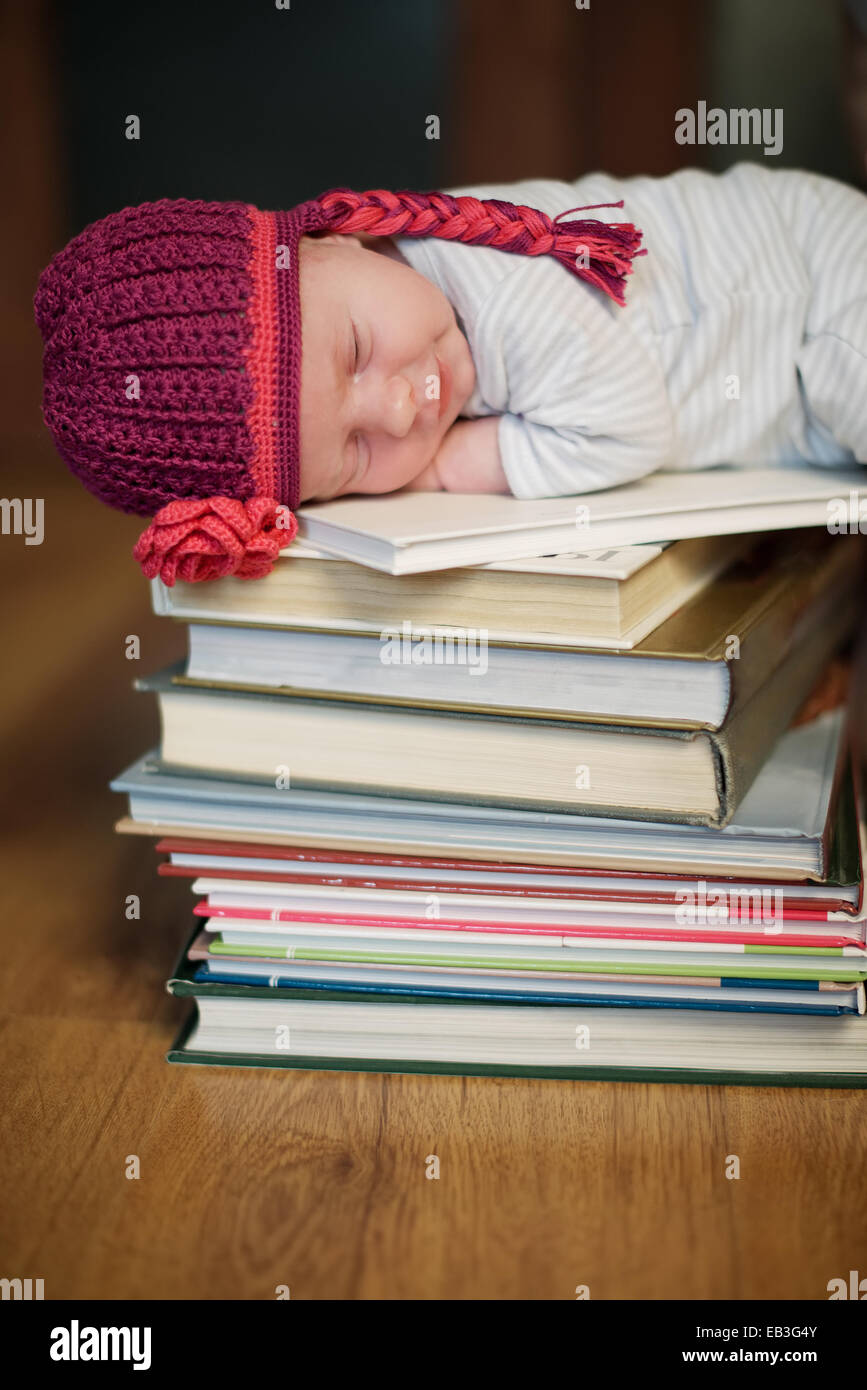 Bébé dort sur pile de livres Photo Stock - Alamy