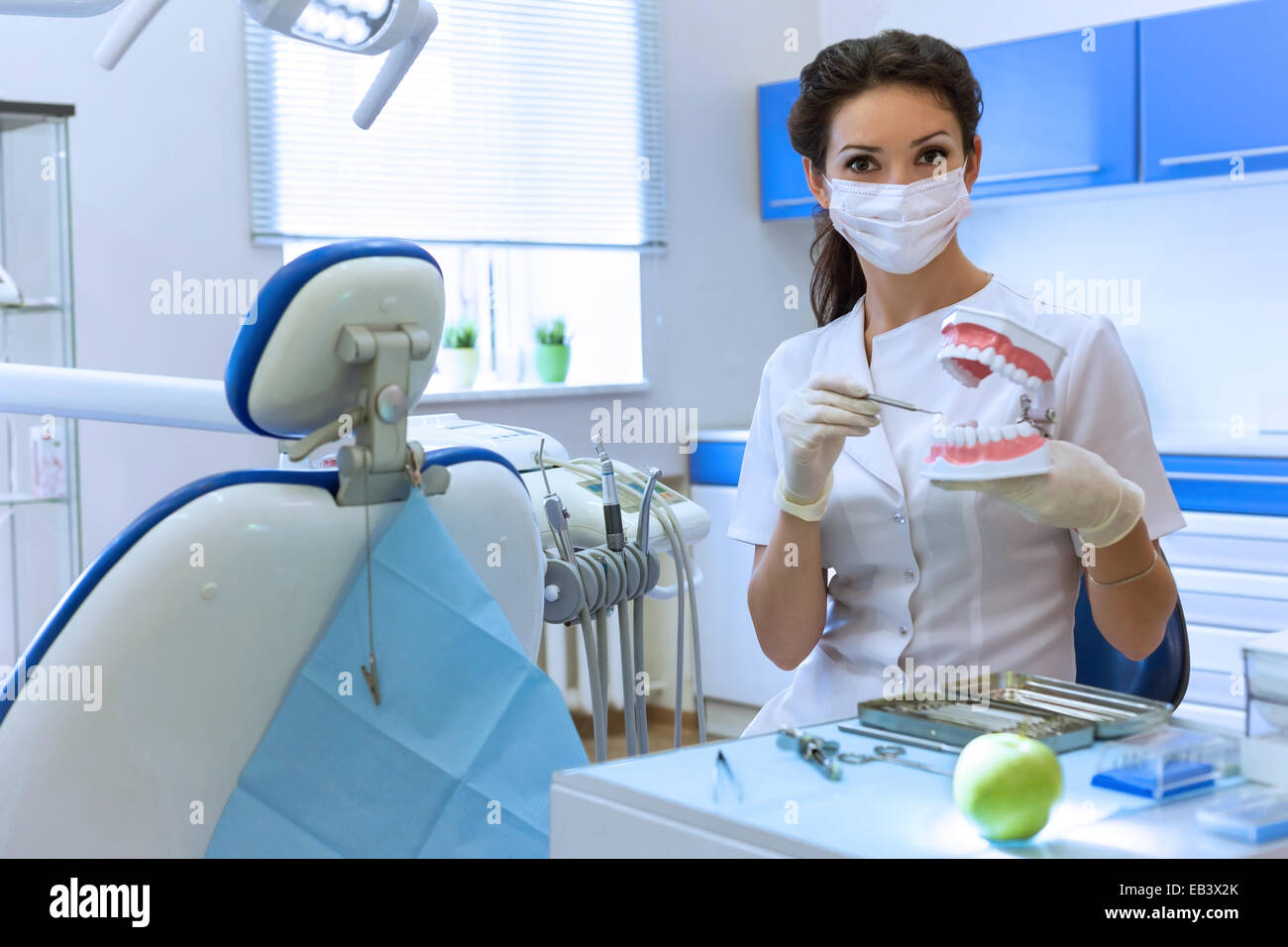 Masque de femme au dentiste stomatologie à l'office holding dental jaw modèle. Concept de soins de santé Banque D'Images