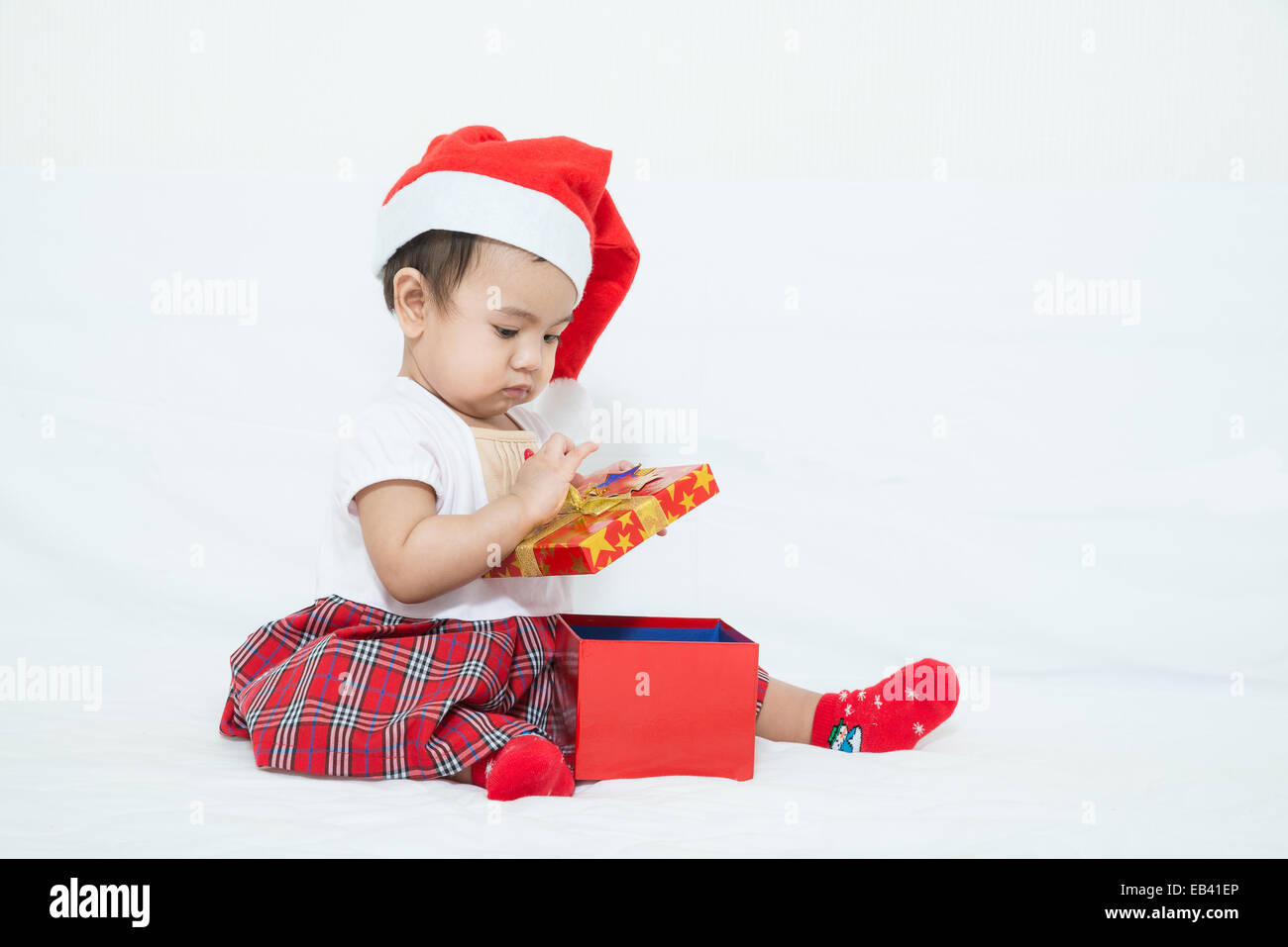 Bébé asiatique avec bouchon de boîte-cadeau de Noël Banque D'Images
